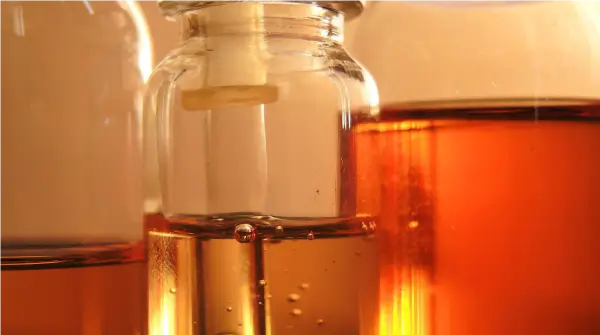 Image of amber viscous oil  or crude hemp oil ready for testing in various glass containers.